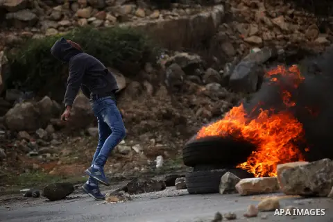 A Palestinian protester throws stones at Israeli troops during clashes next to the Jewish settlement of Beit El, near the West Bank city of Ramallah, November 3, 2015. Meanwhile, Israeli forces early 03 November raided a...