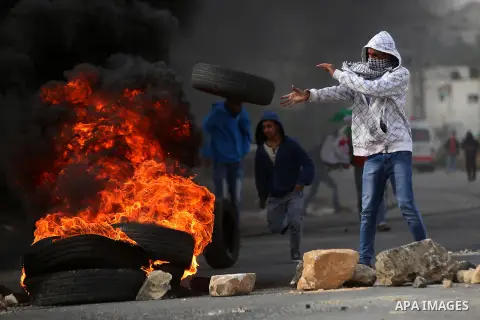 A Palestinian protester burn tires during clashes with Israeli troops next to the Jewish settlement of Beit El, near the West Bank city of Ramallah, November 3, 2015. Meanwhile, Israeli forces early 03 November raided a...