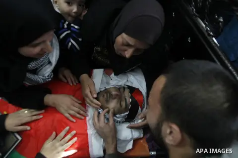 Palestinian relatives around of the body of 23 year old Hassan Al-Baw, who was killed in clashes with Israeli forces, during his funeral in the West Bank village of Halhul, near Hebron, Saturday, Nov. 14, 2015. Photo by...