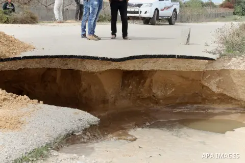 Palestinians stand next to a landslide made by the seawater pumped into the area by the Egyptian army, near the border between Egypt and the southern Gaza Strip, November 25, 2015. Huge water pipes have been installed al...