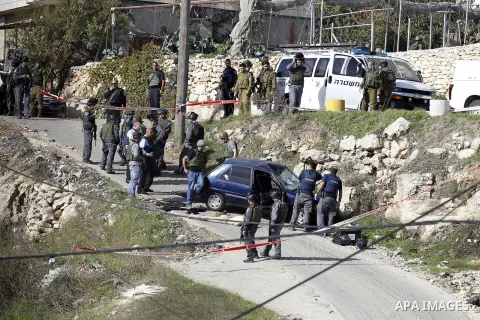 Israeli security forces inspect the body of a Palestinian man who rammed his car into Israeli soldiers injuring five of them before being shot dead, in the village of Beit Ummar, near the city of Hebron in the Israeli oc...