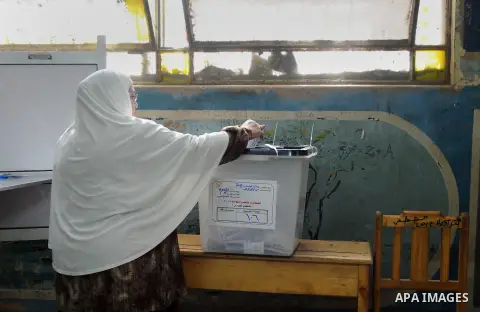 An Egyptian woman casts her ballot at a polling station during the run-off in the second phase of Egypt's parliamentary elections in Shibin El-Kom in the Menufiya province, 60 kilometers north of the capital Cairo, on De...