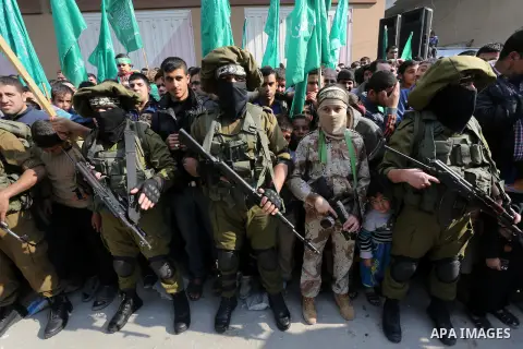 Palestinian militants of the Ezzedine al-Qassam Brigades, the armed wing of the Hamas movement, stand guard during a parade to mark the 28th anniversary of the Islamist movements creation on December 11, 2015, in the Jab...