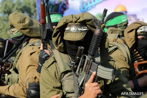 Palestinian militants of the Ezzedine al-Qassam Brigades, the armed wing of the Hamas movement, stand guard during a parade to mark the 28th anniversary of the Islamist movements creation on December 11, 2015, in the Jab...