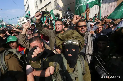 Palestinians attend a military parade of members of al-Qassam Brigades, the armed wing of the Hamas movement, to mark the 28th anniversary of the Islamist movements creation on December 11, 2015, in the Jabalia refugee c...
