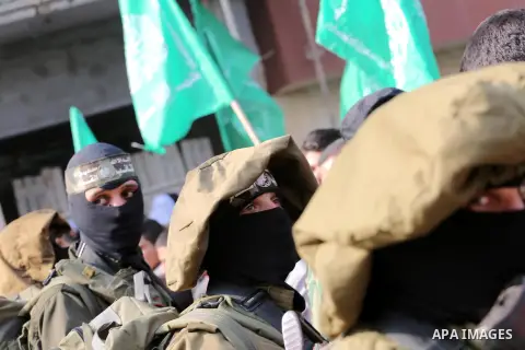 Palestinian militants of the Ezzedine al-Qassam Brigades, the armed wing of the Hamas movement, stand guard during a parade to mark the 28th anniversary of the Islamist movements creation on December 11, 2015, in the Jab...