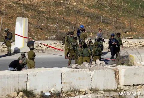 Israeli security forces secure the area after a Palestinian attempted to ram his vehicle into security forces at a military checkpoint on December 11, 2015 at a checkpoint in the West Bank village of Sae'er, near Hebron....