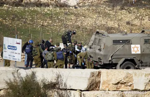 Israeli security forces secure the area after a Palestinian attempted to ram his vehicle into security forces at a military checkpoint on December 11, 2015 at a checkpoint in the West Bank village of Sae'er, near Hebron....