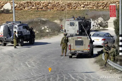 Israeli security forces secure the area after a Palestinian attempted to ram his vehicle into security forces at a military checkpoint on December 11, 2015 at a checkpoint in the West Bank village of Sae'er, near Hebron....