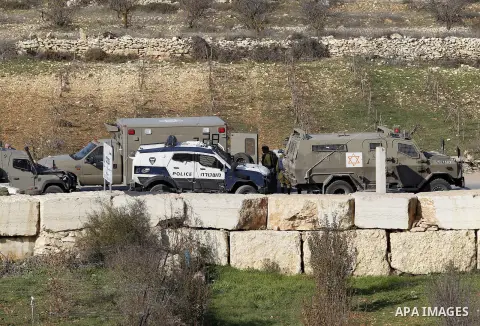 Israeli security forces secure the area after a Palestinian attempted to ram his vehicle into security forces at a military checkpoint on December 11, 2015 at a checkpoint in the West Bank village of Sae'er, near Hebron....