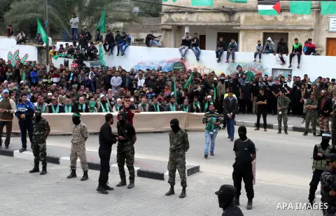 Palestinians attend a military parade by members of the Ezzedine al-Qassam Brigades, the armed wing of the Hamas movement, on December 11, 2015, to mark the ruling Islamist movement's 28th birthday in Khan Yunis, in the...
