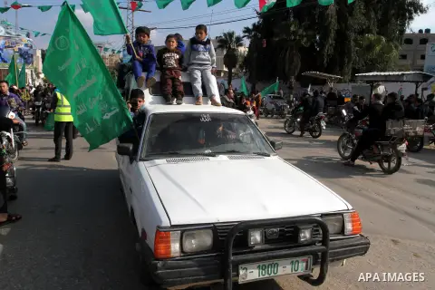 Palestinians attend a military parade by members of the Ezzedine al-Qassam Brigades, the armed wing of the Hamas movement, on December 11, 2015, to mark the ruling Islamist movement's 28th birthday in Khan Yunis, in the...