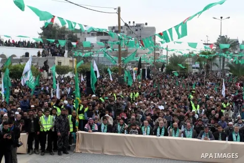 Palestinians attend a military parade by members of the Ezzedine al-Qassam Brigades, the armed wing of the Hamas movement, on December 11, 2015, to mark the ruling Islamist movement's 28th birthday in Khan Yunis, in the...