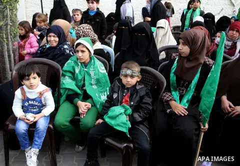 Palestinians attend a military parade by members of the Ezzedine al-Qassam Brigades, the armed wing of the Hamas movement, on December 11, 2015, to mark the ruling Islamist movement's 28th birthday in Khan Yunis, in the...