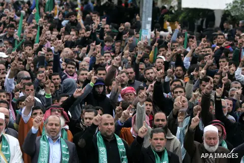 Palestinians attend a military parade by members of the Ezzedine al-Qassam Brigades, the armed wing of the Hamas movement, on December 11, 2015, to mark the ruling Islamist movement's 28th birthday in Khan Yunis, in the...