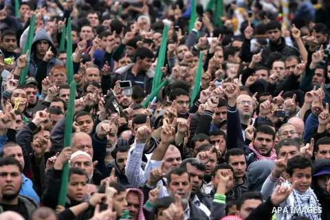 Palestinians attend a military parade by members of the Ezzedine al-Qassam Brigades, the armed wing of the Hamas movement, on December 11, 2015, to mark the ruling Islamist movement's 28th birthday in Khan Yunis, in the...