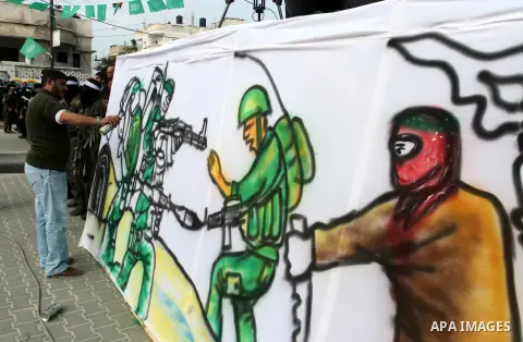 Palestinians attend a military parade by members of the Ezzedine al-Qassam Brigades, the armed wing of the Hamas movement, on December 11, 2015, to mark the ruling Islamist movement's 28th birthday in Khan Yunis, in the...