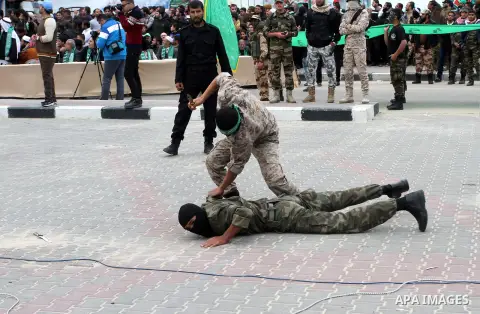 Palestinian militants of the Ezzedine al-Qassam Brigades, the armed wing of the Hamas movement, show their skills during a parade marking the ruling Islamist movement's 28th birthday on December 11, 2015, in Khan Yunis,...