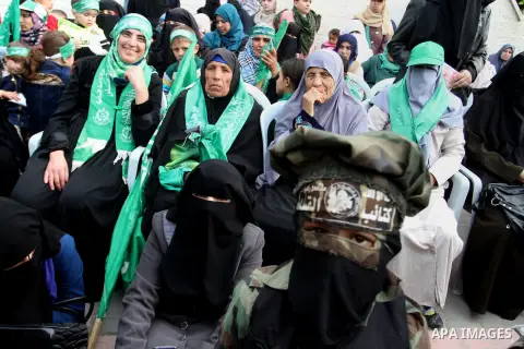 Palestinians attend a military parade by members of the Ezzedine al-Qassam Brigades, the armed wing of the Hamas movement, on December 11, 2015, to mark the ruling Islamist movement's 28th birthday in Khan Yunis, in the...