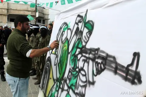 Palestinians attend a military parade by members of the Ezzedine al-Qassam Brigades, the armed wing of the Hamas movement, on December 11, 2015, to mark the ruling Islamist movement's 28th birthday in Khan Yunis, in the...