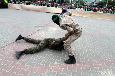 Palestinian militants of the Ezzedine al-Qassam Brigades, the armed wing of the Hamas movement, show their skills during a parade marking the ruling Islamist movement's 28th birthday on December 11, 2015, in Khan Yunis,...