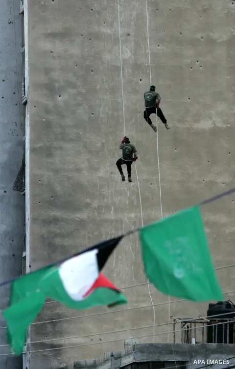 Palestinian militants of the Ezzedine al-Qassam Brigades, the armed wing of the Hamas movement, show their skills during a parade marking the ruling Islamist movement's 28th birthday on December 11, 2015, in Khan Yunis,...