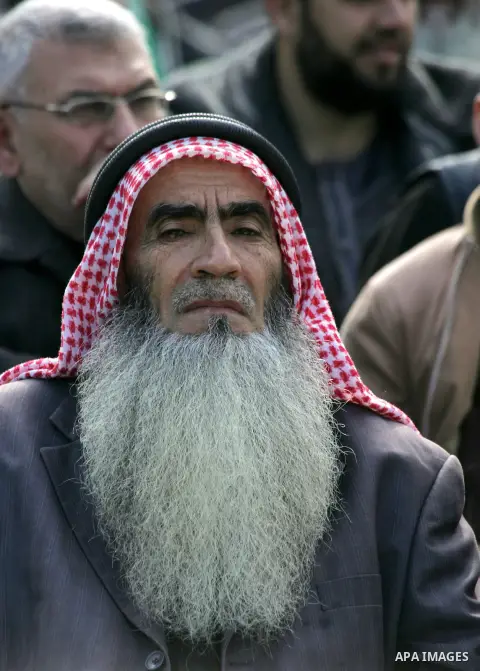 Palestinians attend a military parade by members of the Ezzedine al-Qassam Brigades, the armed wing of the Hamas movement, on December 11, 2015, to mark the ruling Islamist movement's 28th birthday in Khan Yunis, in the...