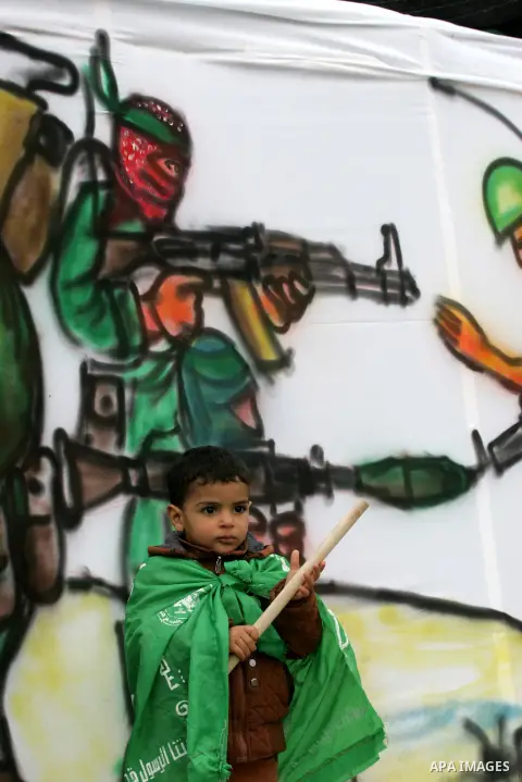 Young Palestinians attend a military parade by members of the Ezzedine al-Qassam Brigades, the armed wing of the Hamas movement, on December 11, 2015, to mark the ruling Islamist movement's 28th birthday in Khan Yunis, i...