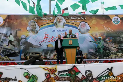 Palestinians attend a military parade by members of the Ezzedine al-Qassam Brigades, the armed wing of the Hamas movement, on December 11, 2015, to mark the ruling Islamist movement's 28th birthday in Khan Yunis, in the...