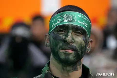 Palestinians attend a military parade by members of the Ezzedine al-Qassam Brigades, the armed wing of the Hamas movement, on December 11, 2015, to mark the ruling Islamist movement's 28th birthday in Khan Yunis, in the...