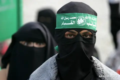 Palestinians attend a military parade by members of the Ezzedine al-Qassam Brigades, the armed wing of the Hamas movement, on December 11, 2015, to mark the ruling Islamist movement's 28th birthday in Khan Yunis, in the...