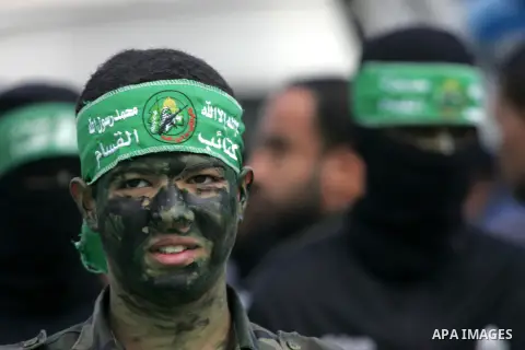 Palestinians attend a military parade by members of the Ezzedine al-Qassam Brigades, the armed wing of the Hamas movement, on December 11, 2015, to mark the ruling Islamist movement's 28th birthday in Khan Yunis, in the...
