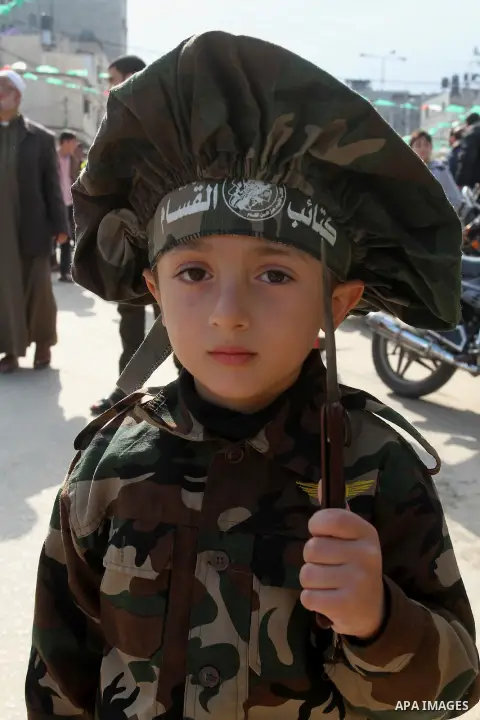 Young Palestinians attend a military parade by members of the Ezzedine al-Qassam Brigades, the armed wing of the Hamas movement, on December 11, 2015, to mark the ruling Islamist movement's 28th birthday in Khan Yunis, i...