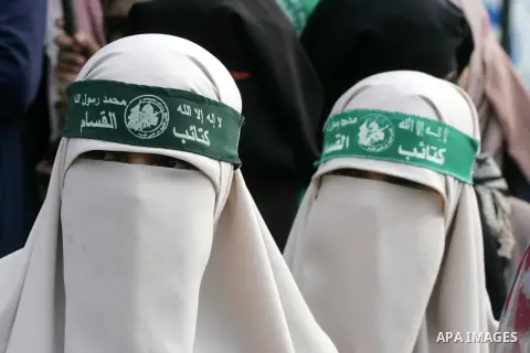 Palestinians attend a military parade by members of the Ezzedine al-Qassam Brigades, the armed wing of the Hamas movement, on December 11, 2015, to mark the ruling Islamist movement's 28th birthday in Khan Yunis, in the...