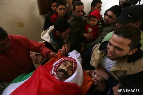 Palestinian mourners carry the body of Sami Madi, who was killed the previous day during clashes with Israeli soldiers on the border fence between the Gaza Strip and Israel, during his funeral in Deir al-Balah, central G...