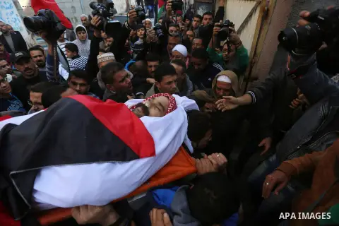 Palestinian mourners carry the body of Sami Madi, who was killed the previous day during clashes with Israeli soldiers on the border fence between the Gaza Strip and Israel, during his funeral in Deir al-Balah, central G...