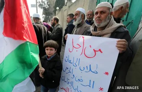 Palestinians hold banners during a protest demanding the Egyptian authorities for the opening of the Rafah crossing in front of the Egyptian embassy, in Gaza city, on Dec. 13, 2015. Photo by Mohammed Asad