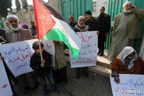 Palestinians hold banners during a protest demanding the Egyptian authorities for the opening of the Rafah crossing in front of the Egyptian embassy, in Gaza city, on Dec. 13, 2015. Photo by Mohammed Asad