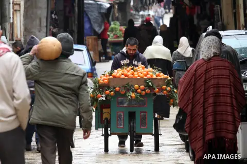 Palestinians walk at a street during a rainy day, in the West Bank city of Nablus on Dec. 13, 2015. Photo by Nedal Eshtayah
