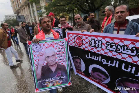 Palestinians take part in a protest demanding release the prisoners in Israeli jails, in front of Red cross office, in Gaza city, on Dec. 14, 2015. Photo by Mohammed Asad