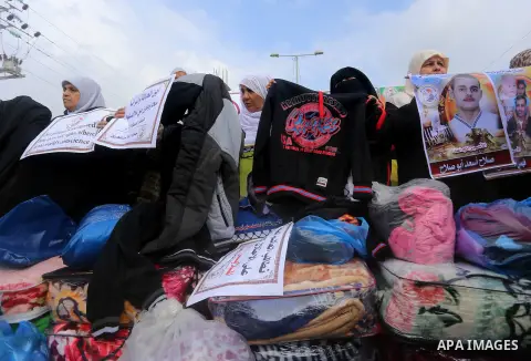 Relatives of Palestinian prisoners take part in a protest demanding to the entery of the winter clothing for their prisoners in Israeli jails, outside Eriz crossing in the northern Gaza Strip, on Dec. 17, 2015. Photo by...