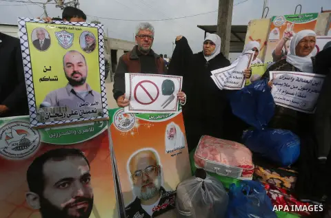 Relatives of Palestinian prisoners take part in a protest demanding to the entery of the winter clothing for their prisoners in Israeli jails, outside Eriz crossing in the northern Gaza Strip, on Dec. 17, 2015. Photo by...