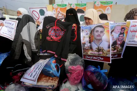 Relatives of Palestinian prisoners take part in a protest demanding to the entery of the winter clothing for their prisoners in Israeli jails, outside Eriz crossing in the northern Gaza Strip, on Dec. 17, 2015. Photo by...