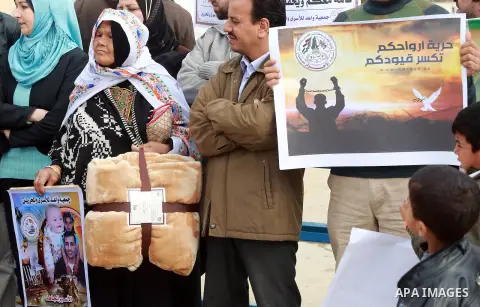 Relatives of Palestinian prisoners take part in a protest demanding to the entery of the winter clothing for their prisoners in Israeli jails, outside Eriz crossing in the northern Gaza Strip, on Dec. 17, 2015. Photo by...