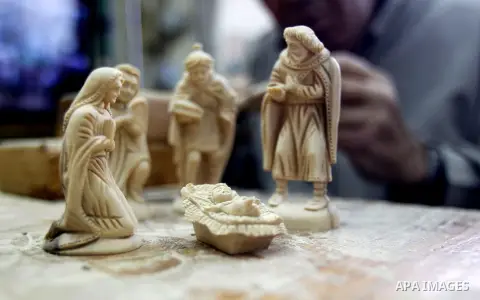 A Palestinian carpenter carves a wooden effigies of the the Holy Family at a workshop in the West Bank town of Bethlehem, on December 17, 2015. The traditional birthplace of Jesus Christ prepares to celebrate Christmas l...