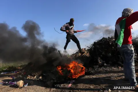 Palestinian protesters clash with Israeli security forces along the border with Israel in the eastern suburbs of Gaza City on December 18, 2015. A wave of violence has hit the Palestinian Territories, Jerusalem and Israe...