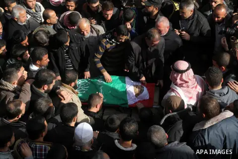 Mourners gather around the body of Palestinian Mahmoud Al-Aga, 20, whom medics said was killed by Israeli troops during clashes with Palestinian protesters on Friday, during his funeral in Khan Younis in the southern of...