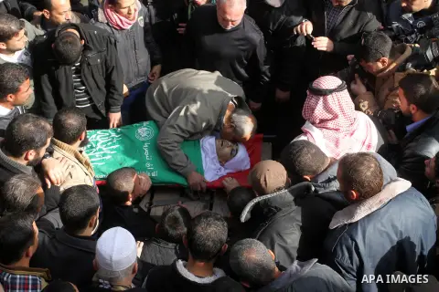 Mourners gather around the body of Palestinian Mahmoud Al-Aga, 20, whom medics said was killed by Israeli troops during clashes with Palestinian protesters on Friday, during his funeral in Khan Younis in the southern of...