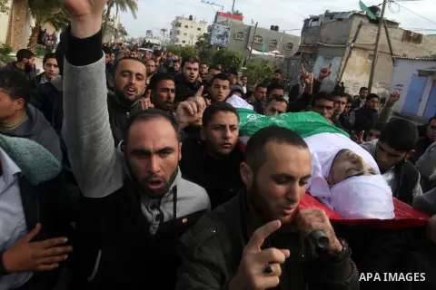 Mourners carry the body of Palestinian Mahmoud Al-Aga, 20, whom medics said was killed by Israeli troops during clashes with Palestinian protesters on Friday, during his funeral in Khan Younis in the southern of Gaza Str...