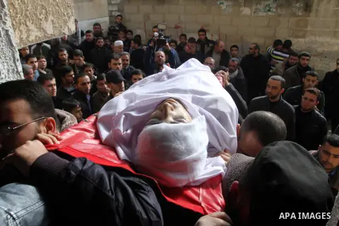 Mourners carry the body of Palestinian Mahmoud Al-Aga, 20, whom medics said was killed by Israeli troops during clashes with Palestinian protesters on Friday, during his funeral in Khan Younis in the southern of Gaza Str...